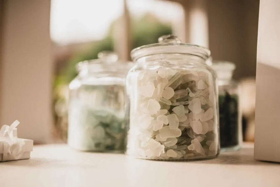 Glass jars holding sea glass sorted by colour in Violine’s studio
