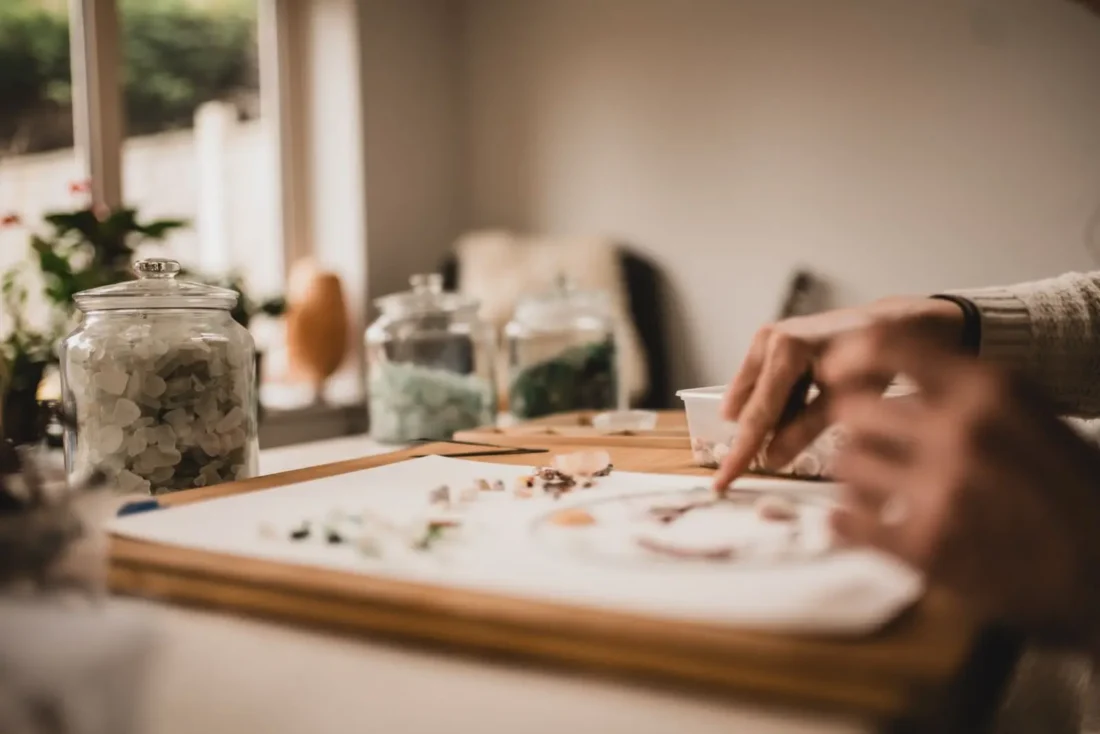 Violine selecting and arranging sea glass at her worktable